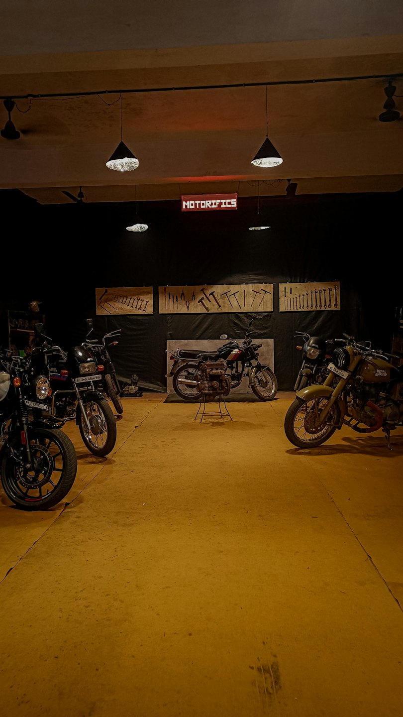 Motociclette e un banco da lavoro all'interno di un'officina poco illuminata.